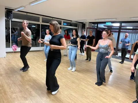 Beginners practicing their first Bachata steps together at AXcent Dance in Zurich