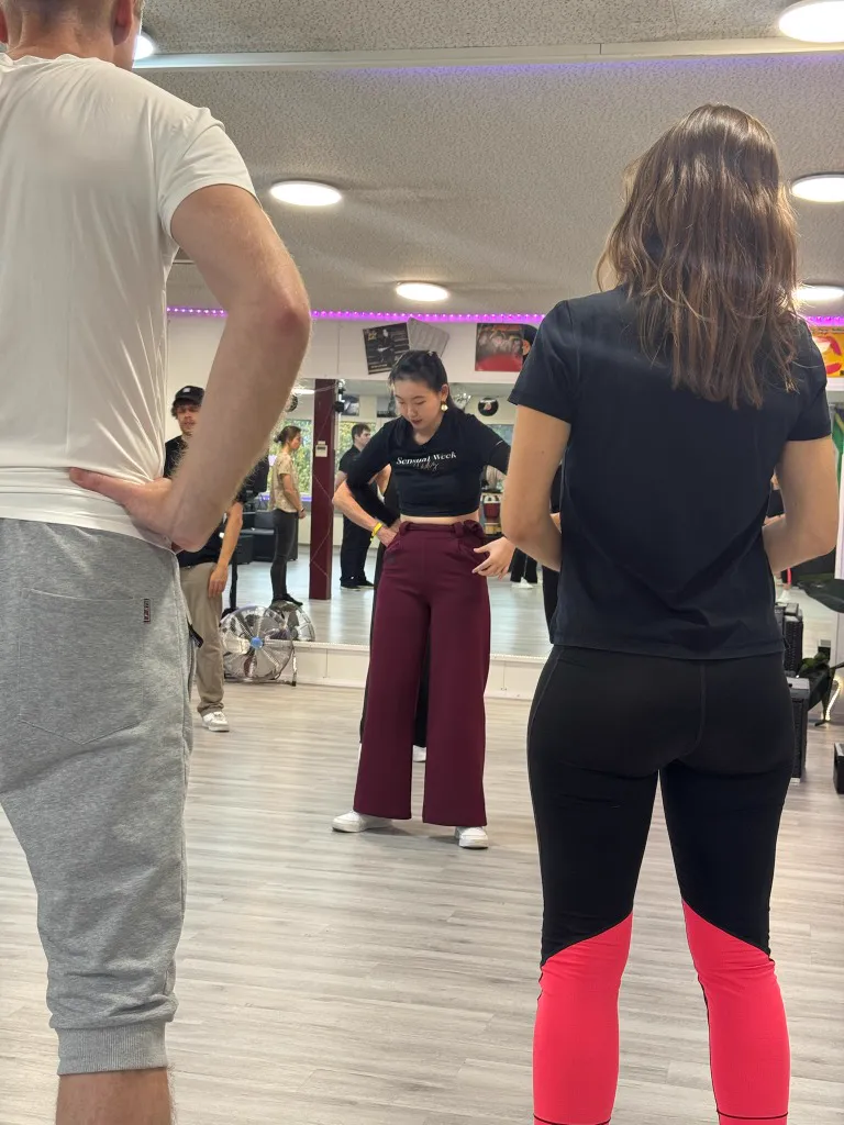 Students practicing footwork in the dance studio mirror