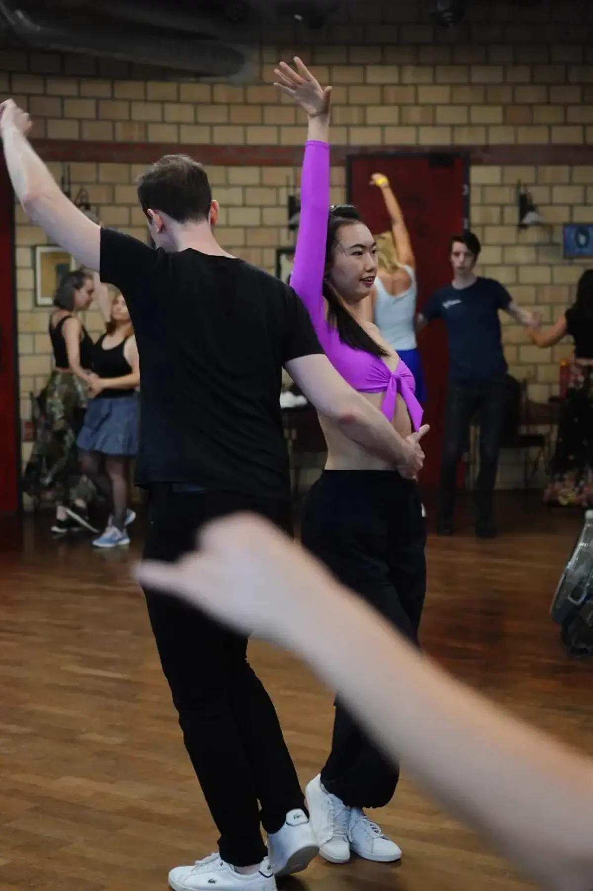 Two AXcent Dance students holding a styled connection during a Bachata class in Zurich