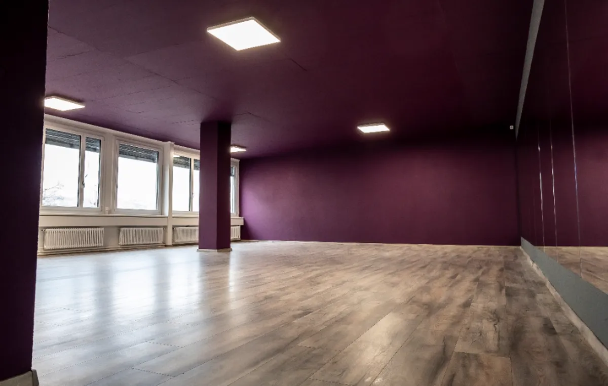 Geräumiges Tanzstudio mit violetter Decke und Spiegeln